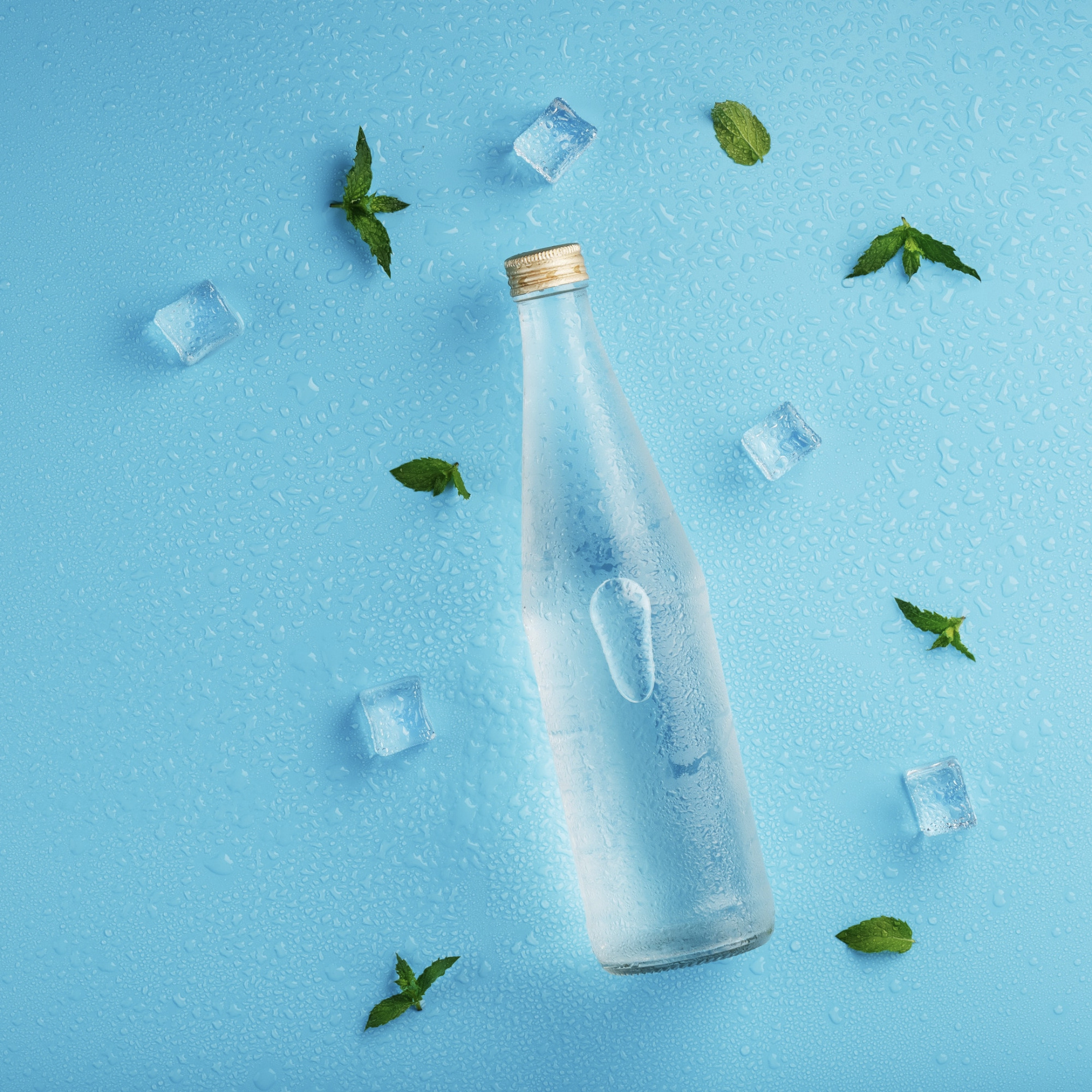 Una bottiglia di acqua in vetro con gocce di condensa